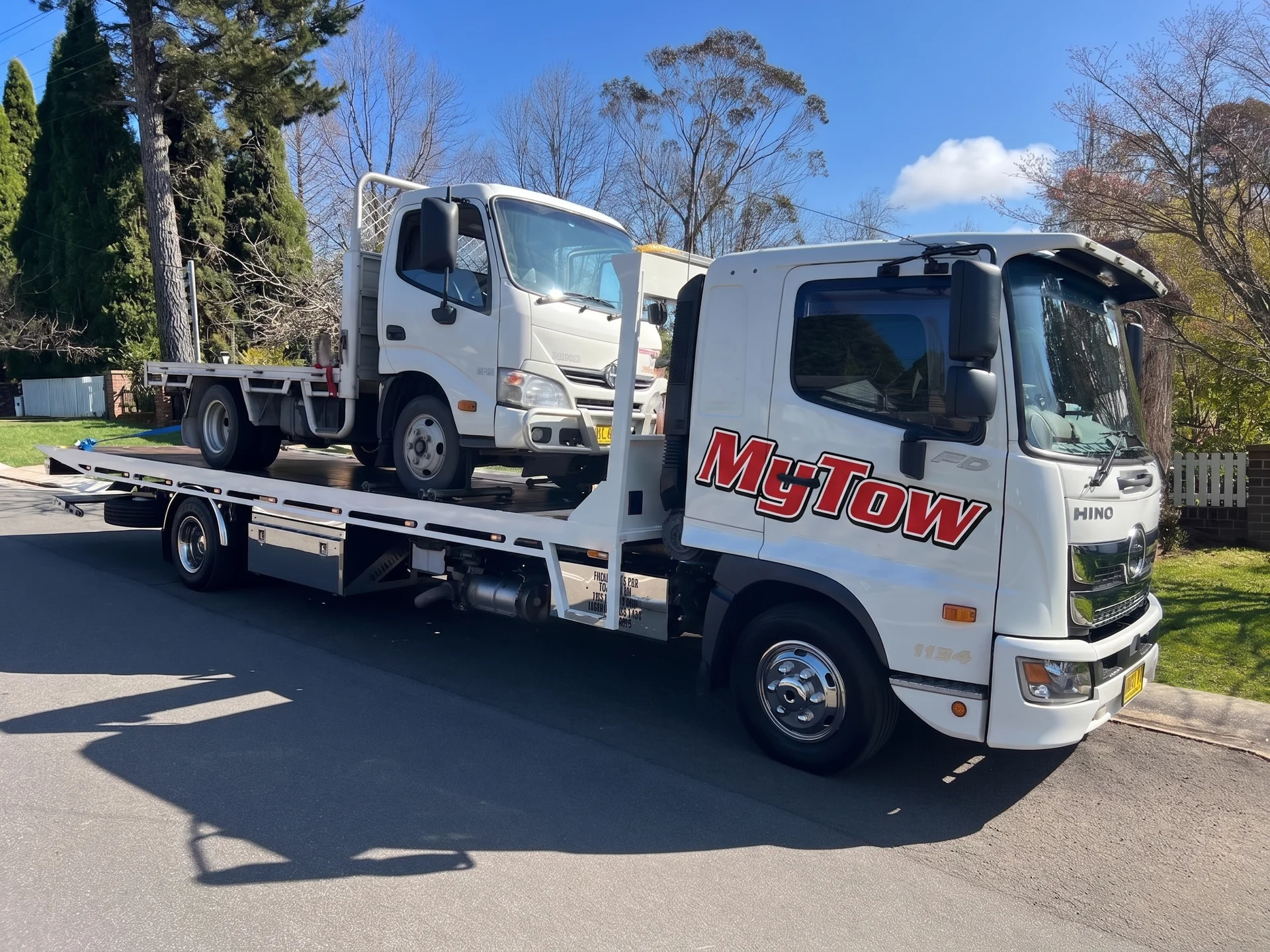 Tow truck transporting a smaller truck