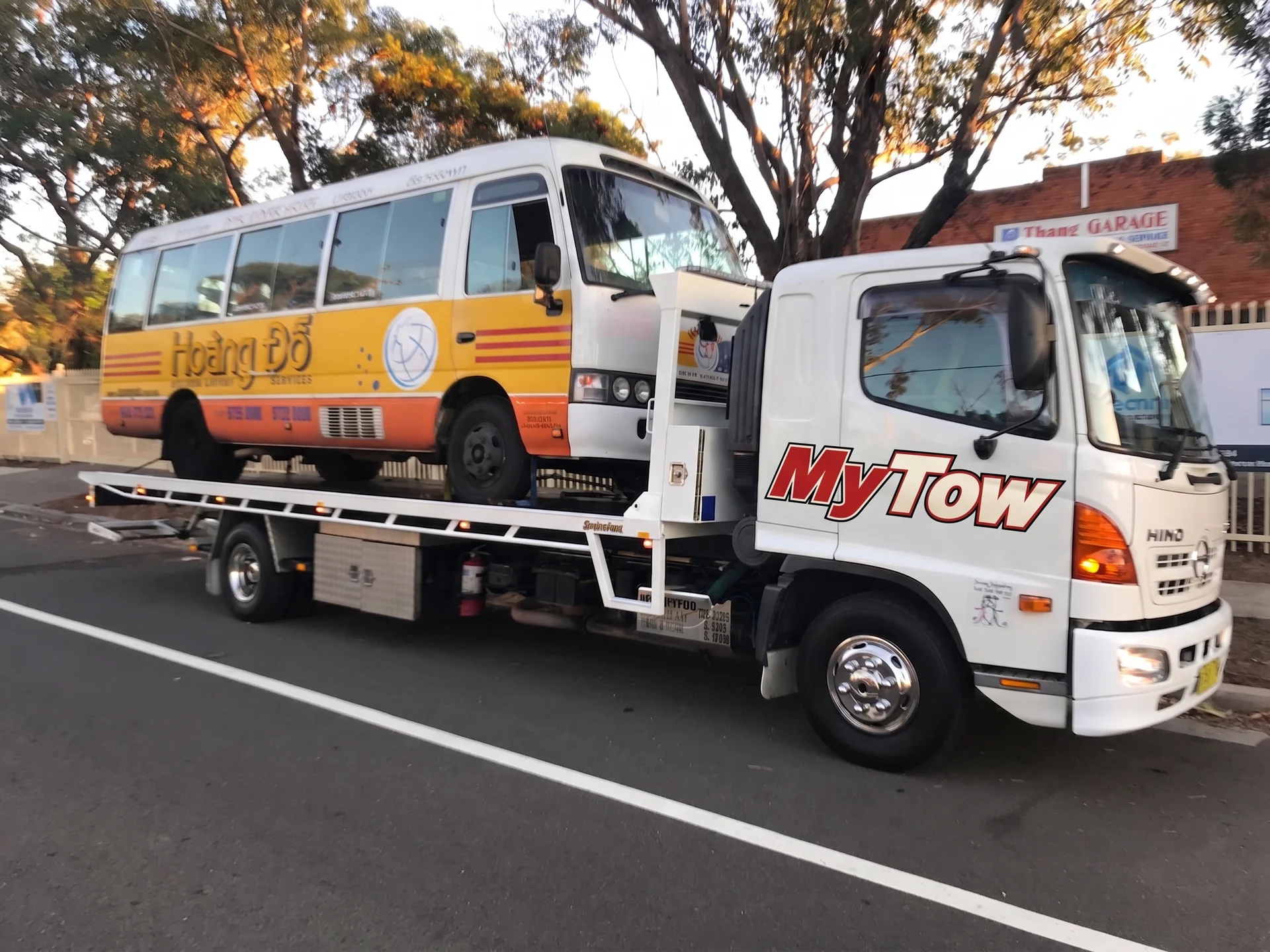 Tow truck transporting a small bus