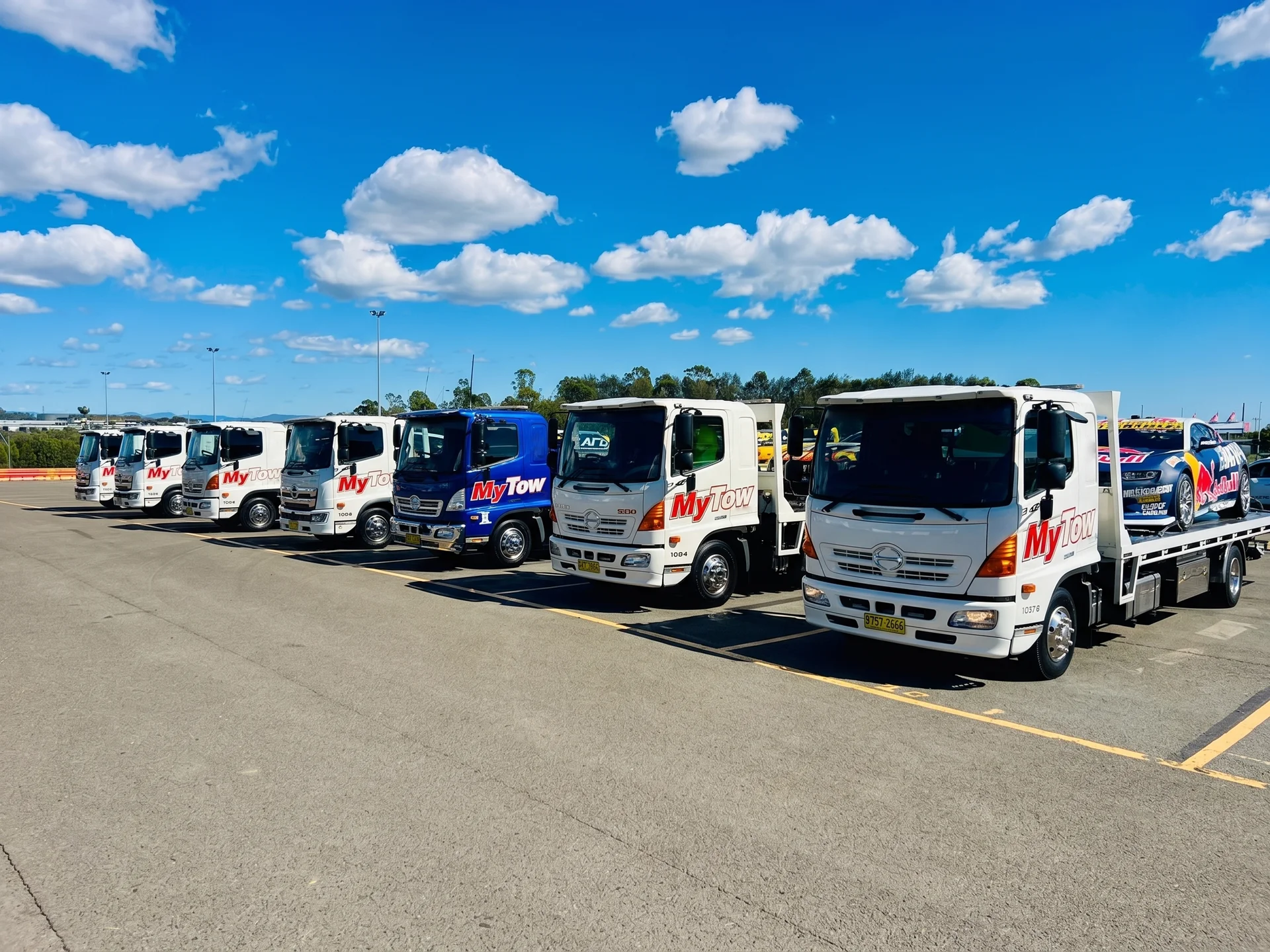 Row of tow trucks parked under blue sky