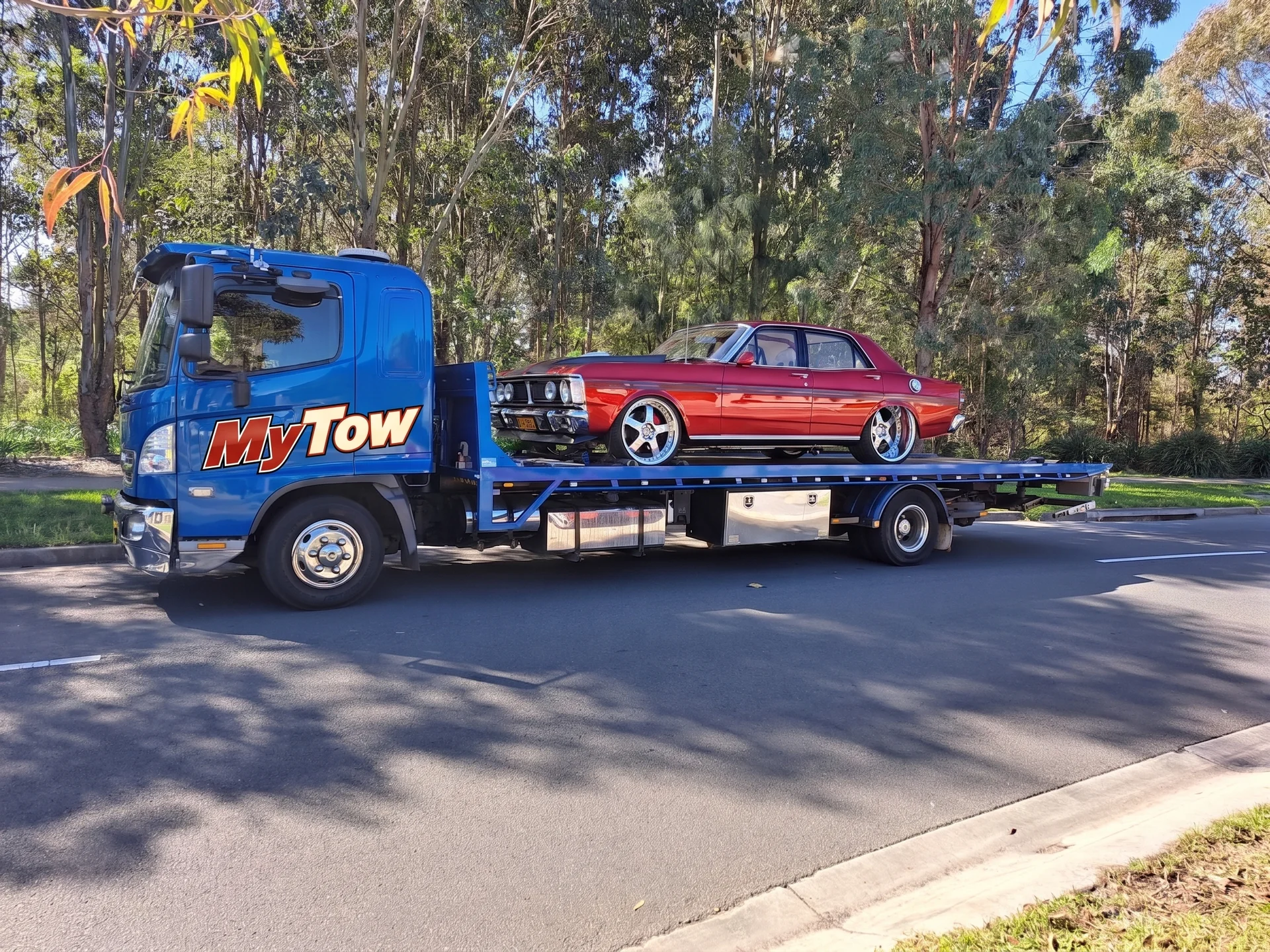 Tow truck carrying a classic red car