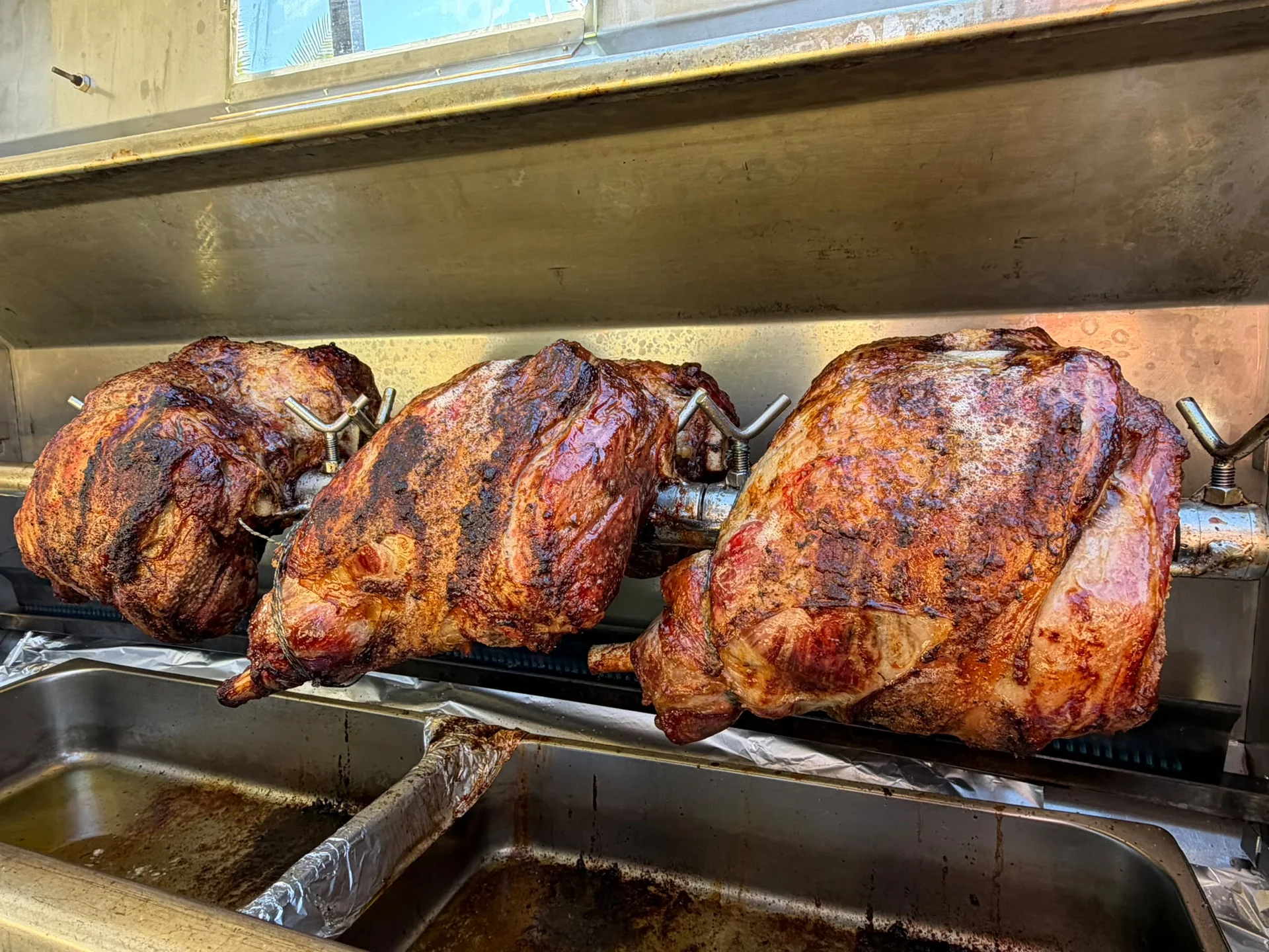 Roasted meats on a rotisserie grill